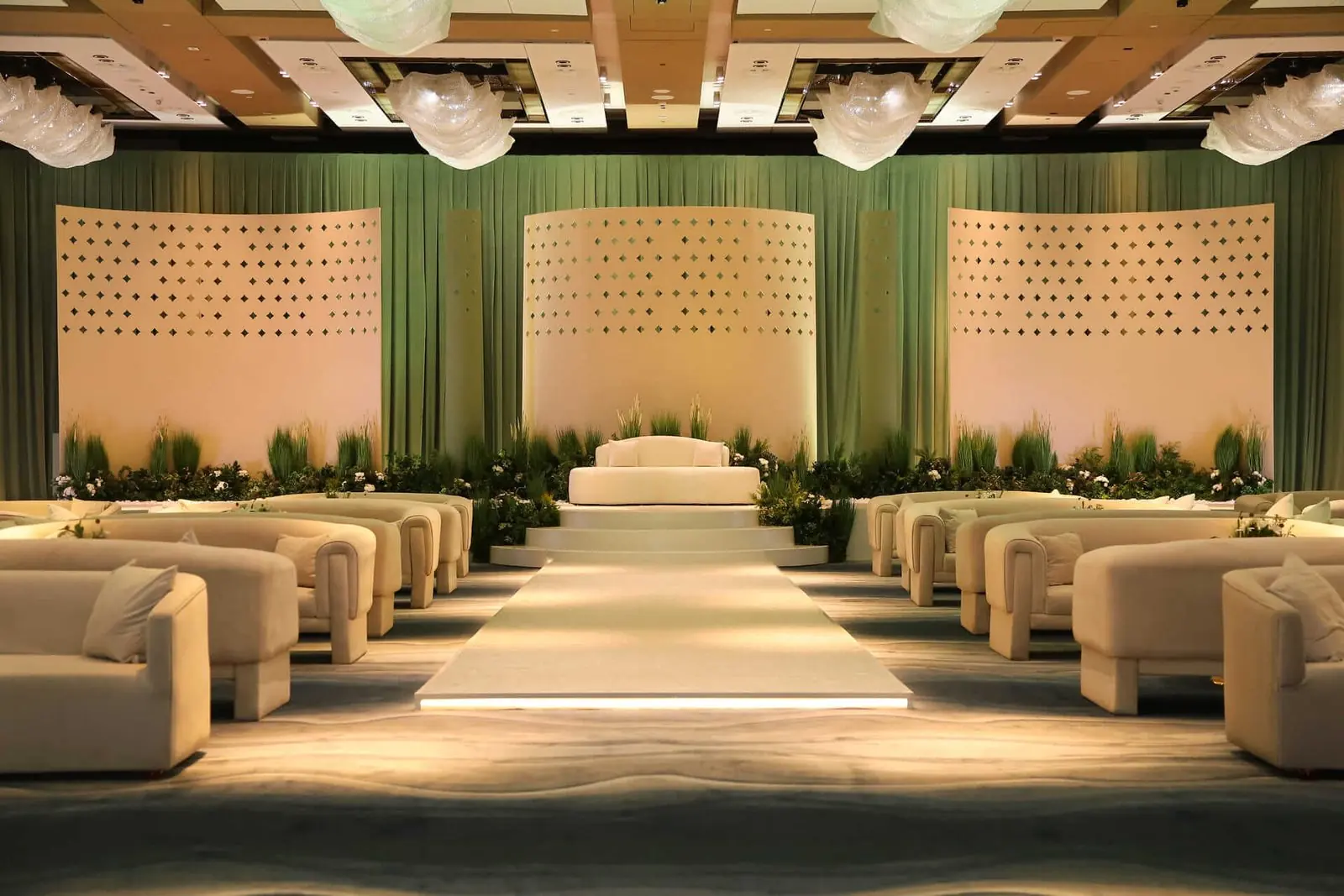 Lit catwalk aisle between rows of ivory lounges