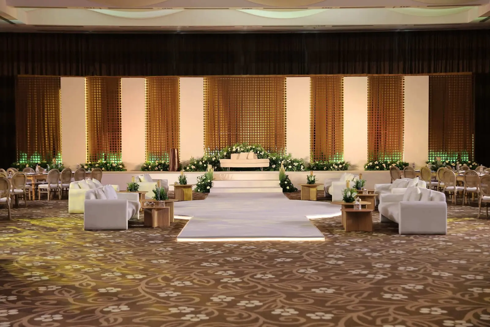 Wood panel stage with lounges and greenery
